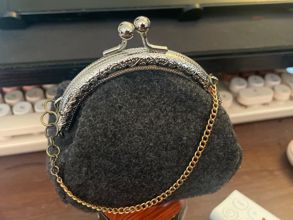 A small coin purse with a small gold chain