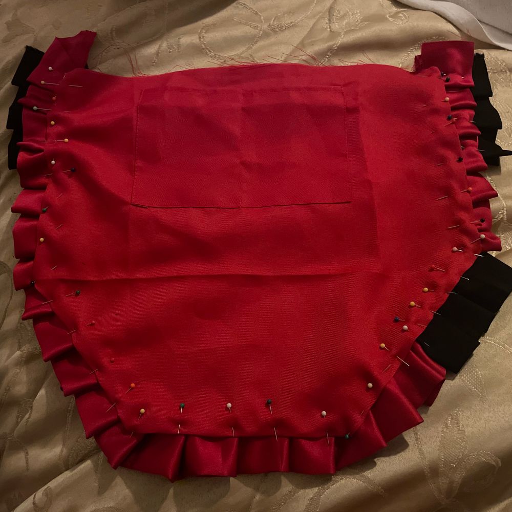 A red and black apron being put together