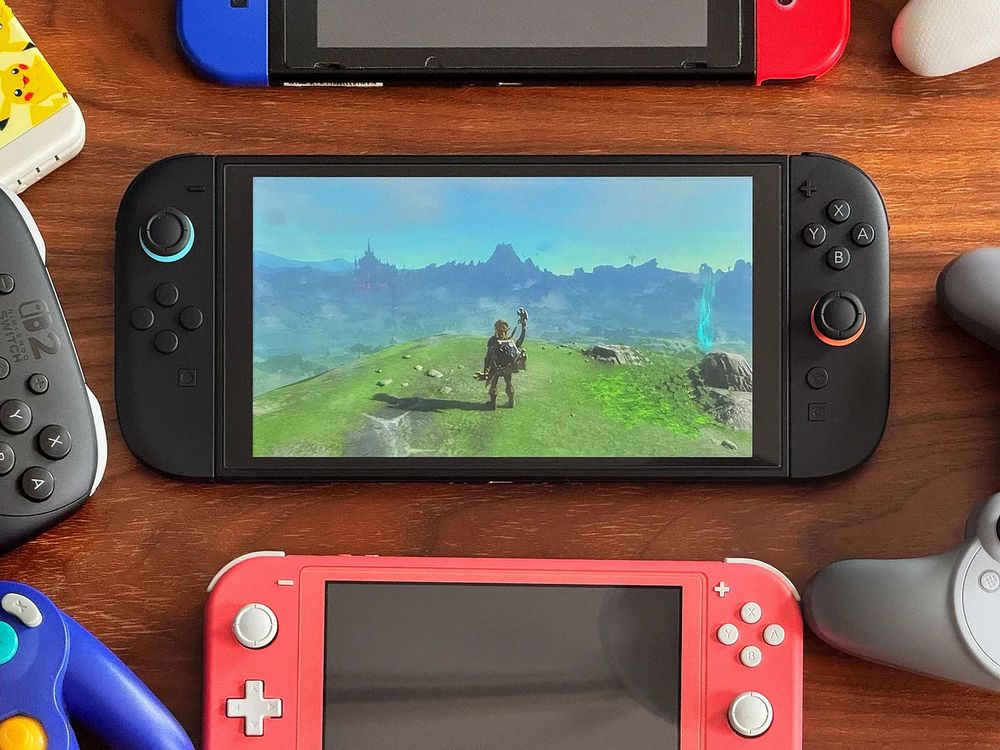 Nintendo Switch 2 hardware surrounded by controllers and past Switch consoles. The Legend of Zelda is on the Switch 2 screen