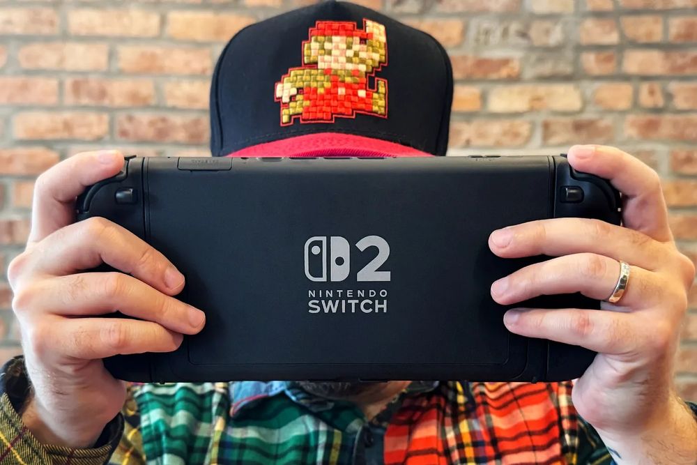 Me holding the Switch 2 in front of my face, totally natural way to hold a console, with a Mario baseball cap overlooking