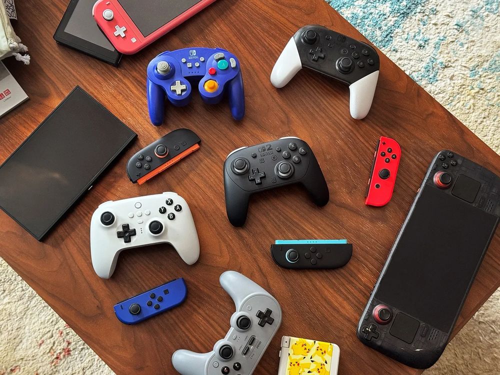 An assortment of Nintendo Switch related hardware, with the Pro 2 controller in the middle, and also a Steam Deck off to the side