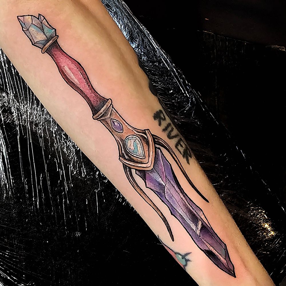 Tattoo of a coloured mystical crystal dagger encrusted with jewels 