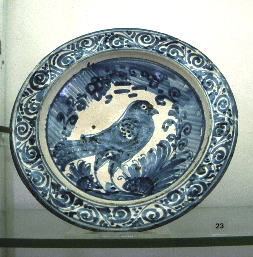 Tin-glaze plate from Spain with an inky blue decorations of a large bird and botanicals.