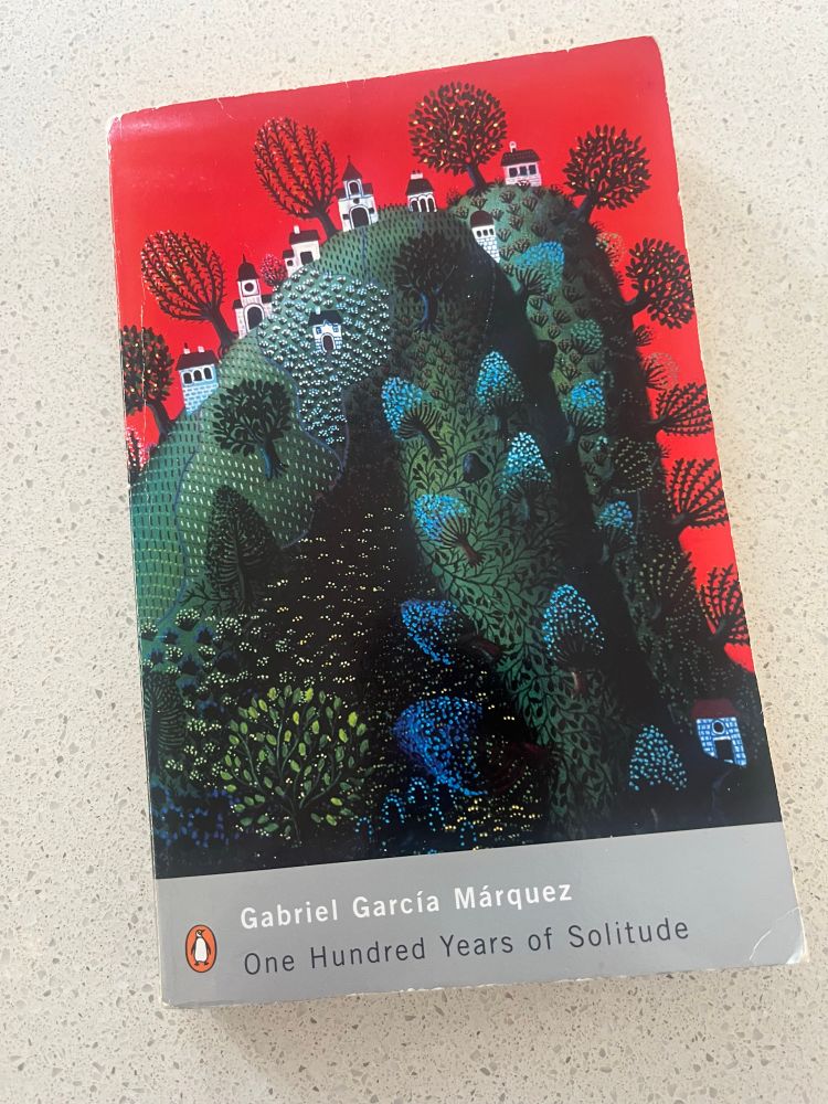 Book cover with fantastical image houses dotted among trees on a hill. 