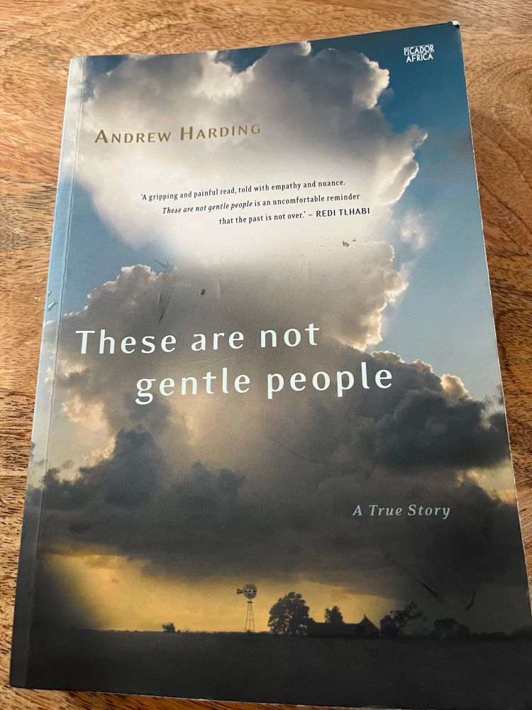 A book cover showing a farm silhouetted against a brooding sky. 