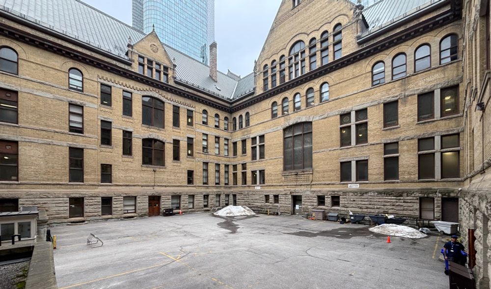 The inner courtyard of Toronto’s old City Hall, a gabled building whose walls are made of yellow brick