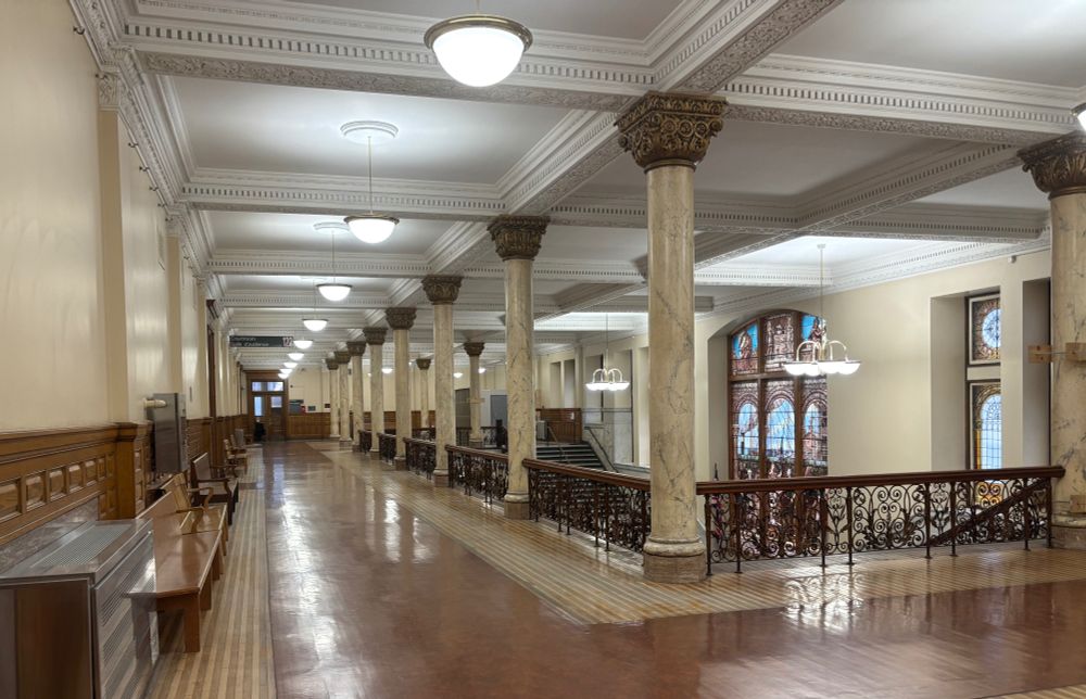 A large corridor with ornate woodwork and decorated columns s 