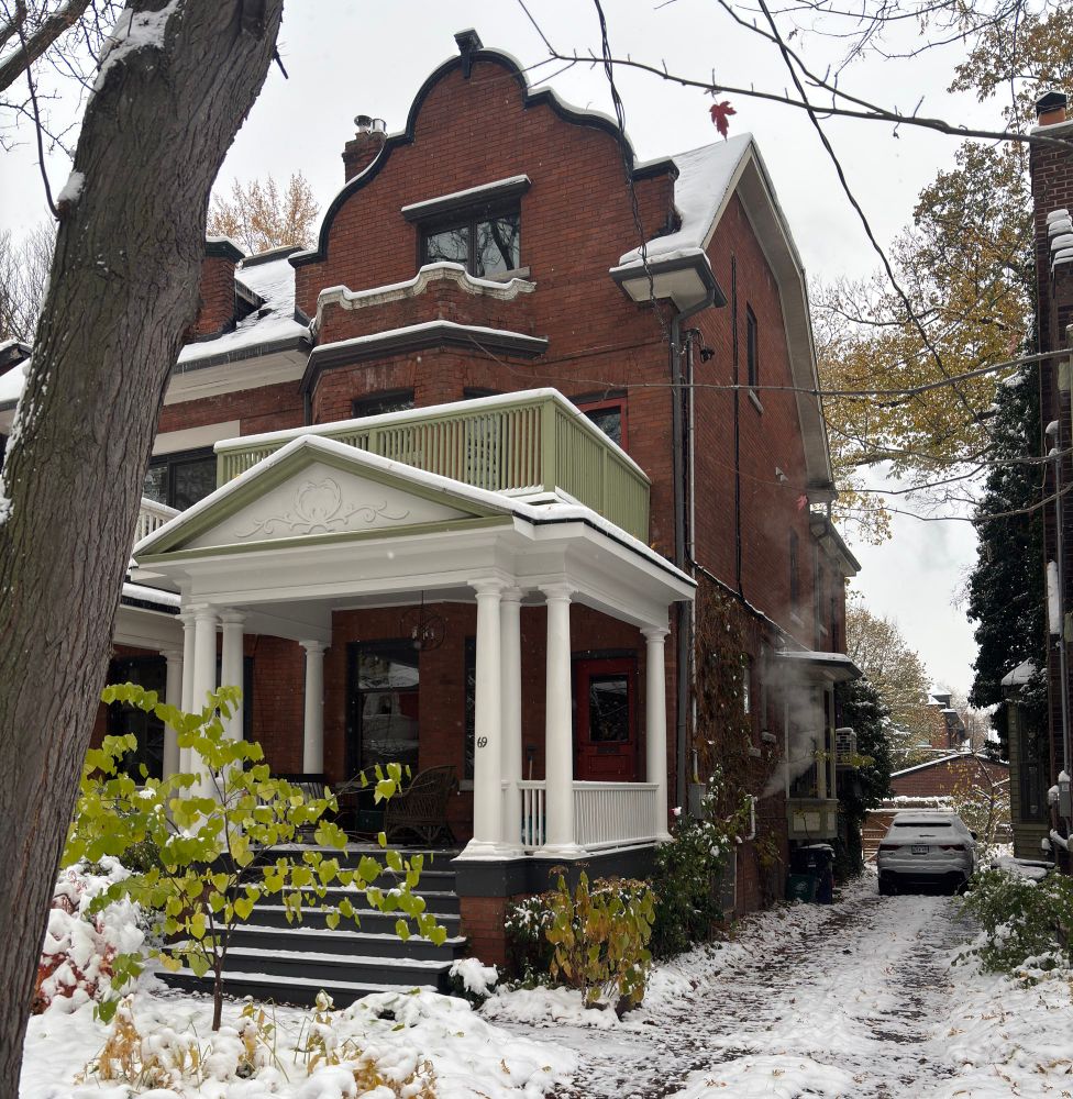 The house at 69 Albany Ave. in Toronto, where the urbanist Jane Jacobs lived, with an Audi SUV in the driveway