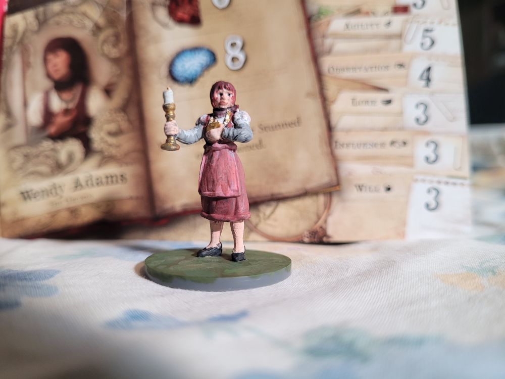 Wendy in front of her character card facing slightly to the left but her face is looking at the camera 