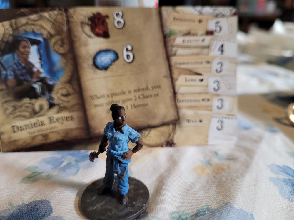 Daniela in front of her character card. She is slightly facing left from the front 