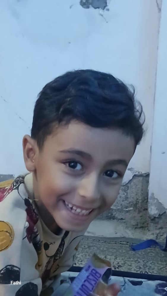 Boody smiles for the camera. In the background are damaged walls 