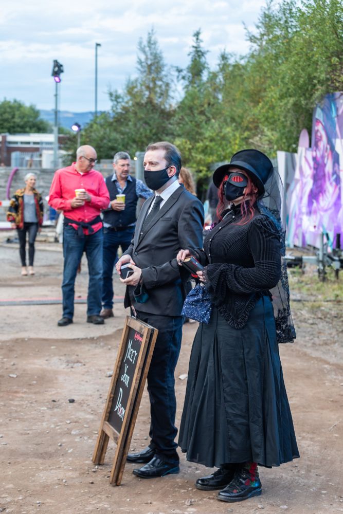 Two funereal-looking figures, Dr Devilsfield and The Seer, stand waiting for querants at the Hidden Door Festival in 2021. 