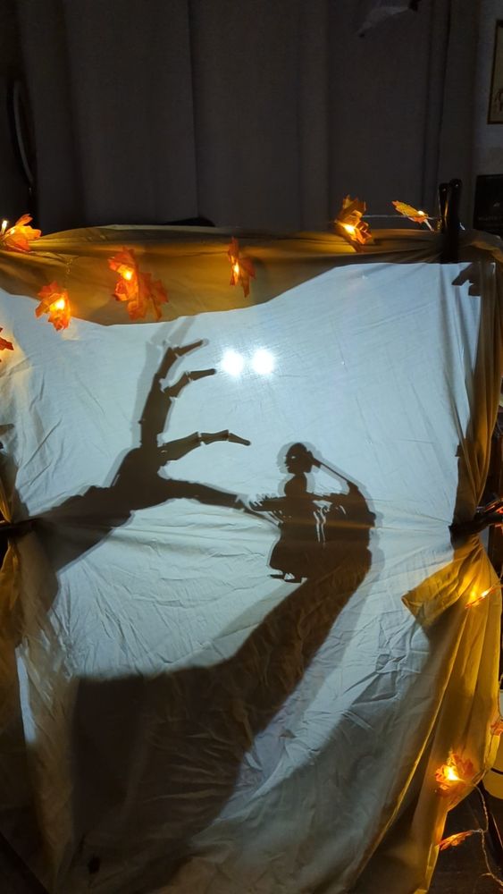 A shadow puppet experiment showing a small woman being menaced by a skeletal hand. 