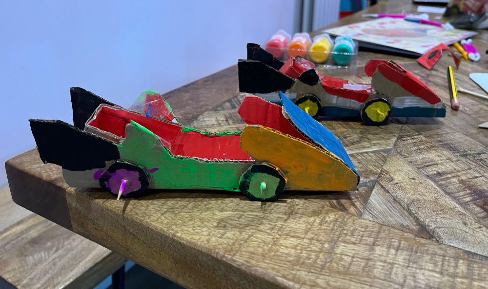 A picture of two cardboard mario kart style karts on a table. 