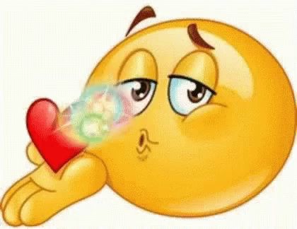 a cartoon smiley face is blowing a kiss while holding a heart .