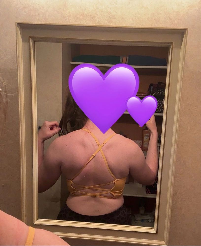 mirror pic of me with back facing the mirror and a yellow strappy sports bra and black leggings 