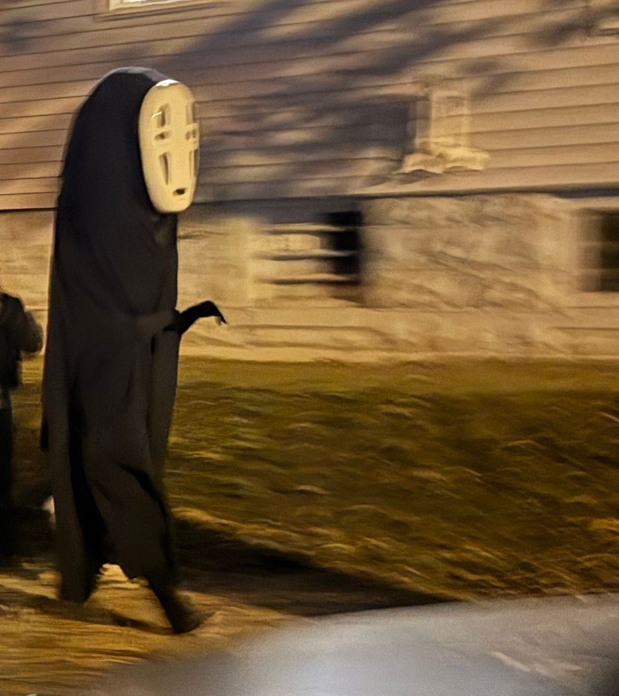 A person dressed in a very tall No Face costume. (From Spirited Away)