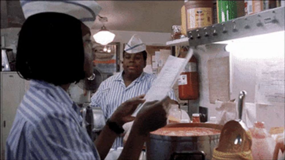 a man in a striped shirt is reading a menu in a restaurant