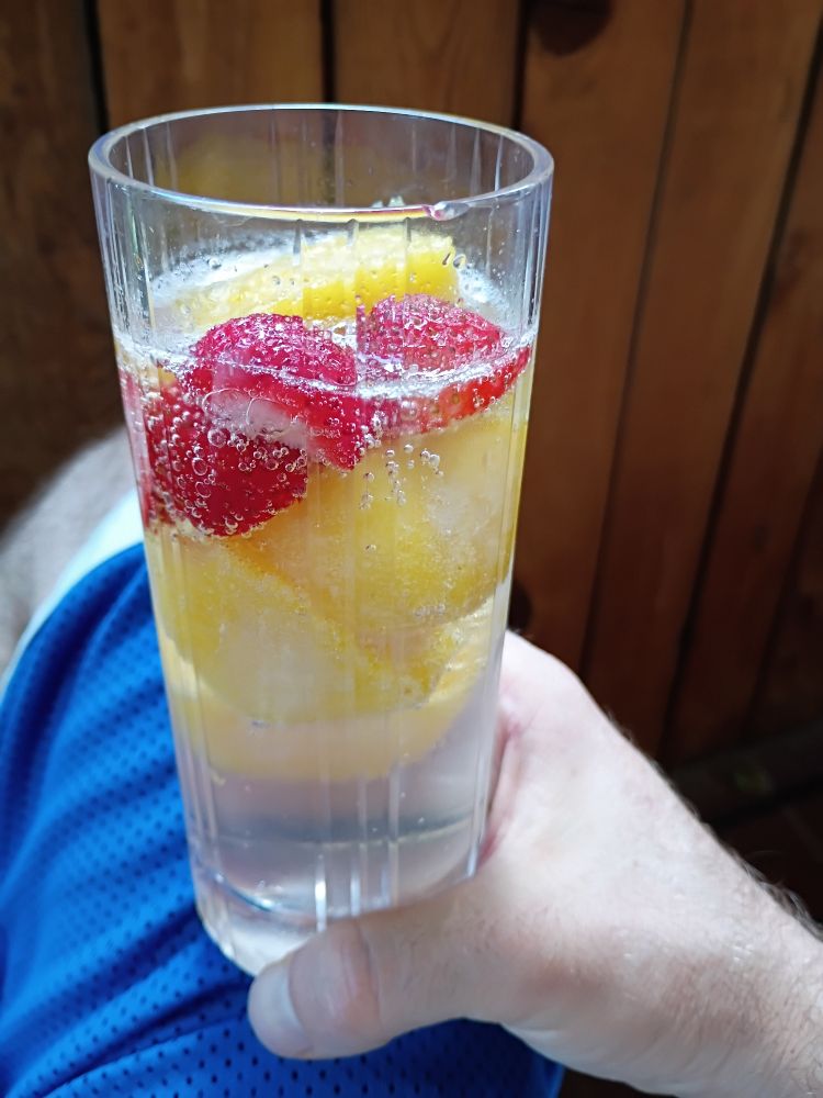 Sprite in a clear glass with ice cubes made out of leftover unchurned pineapple lime sorbet and fresh strawberries