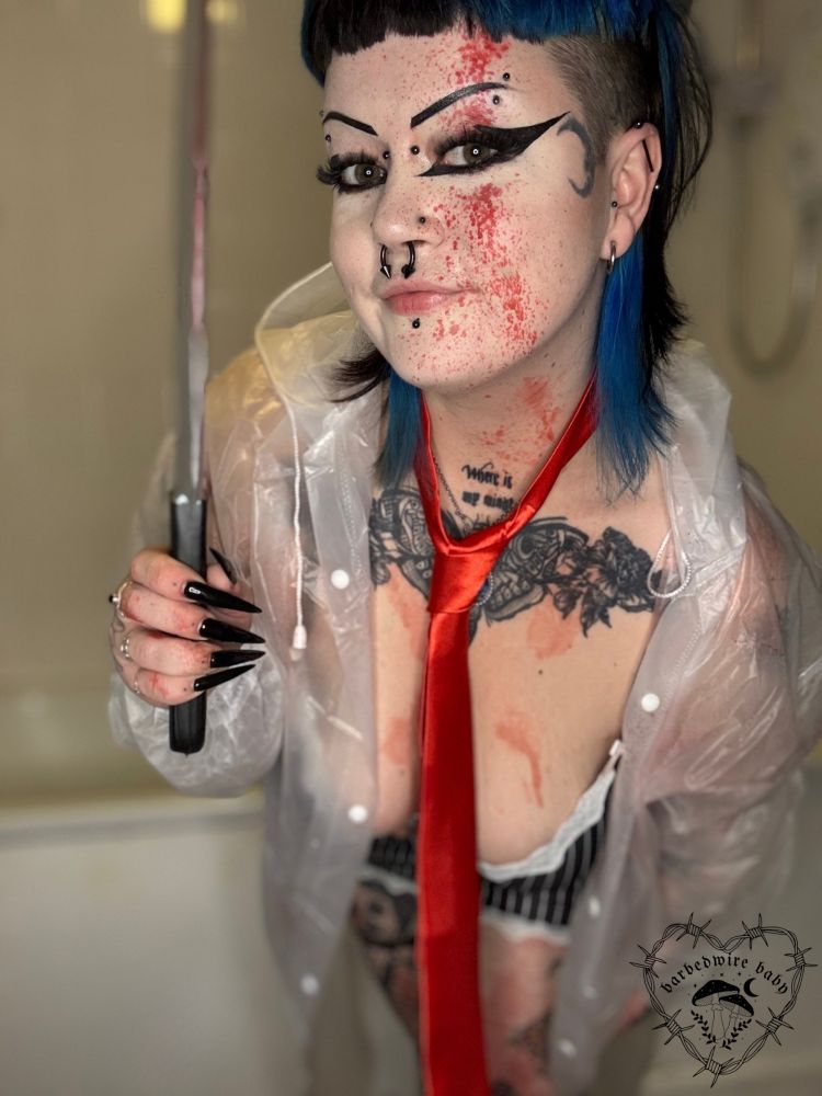 Bug is now stood further away and they are leaning forward. They have removed the shirt to show their pinstripe bra, but are still wearing the tie and rain mac. They are looking at the camera with a slight smile and holding the cleaver. 