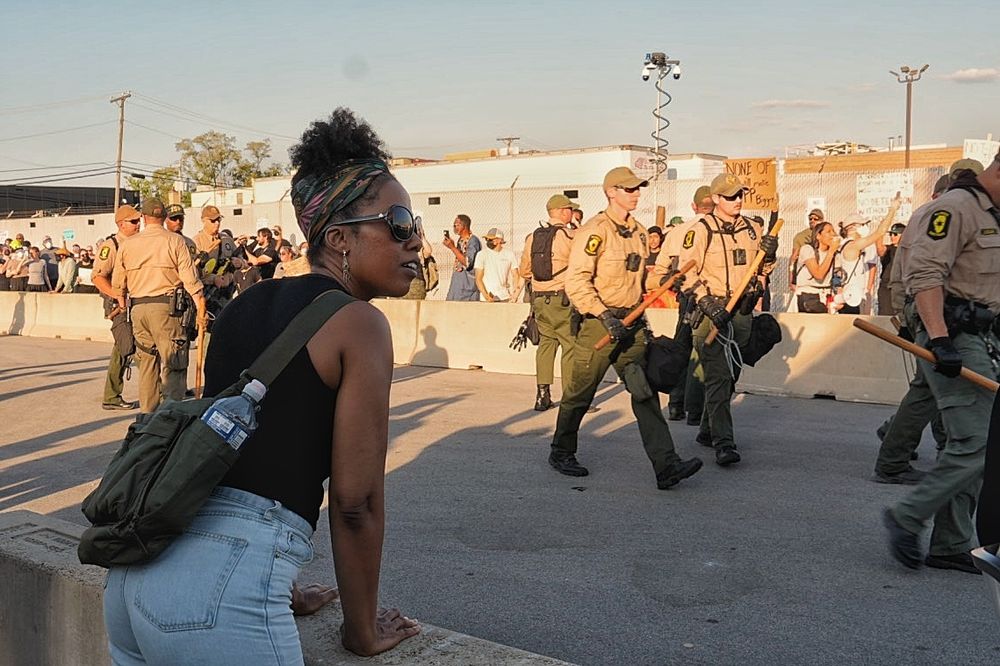 Protester watches state troopers from behind cement barricade 