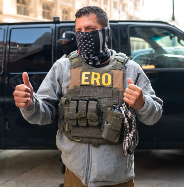 ERO Chicago agent in gray hoodie and black and white American flag gaiter (with red stripe for firefighters)