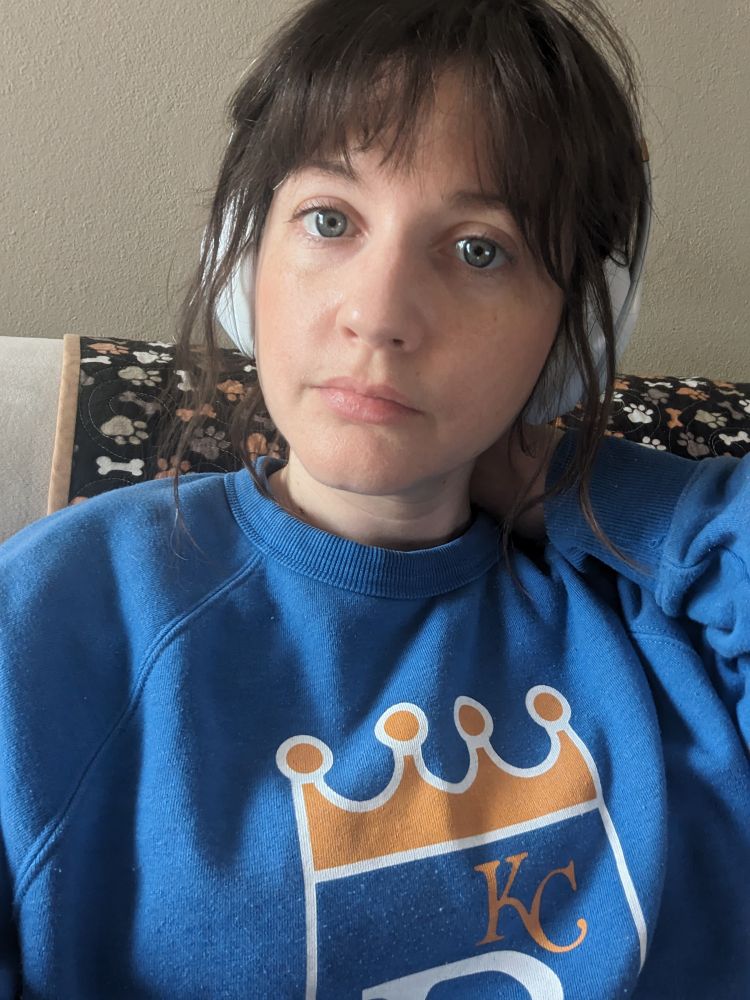 No makeup, wearing headphones, Royals sweatshirt
