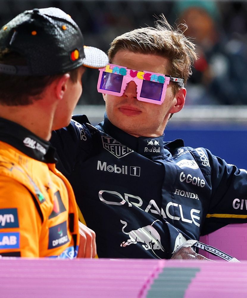 Max Verstappen wearing LEGO glasses in the pink LEGO Cadillac after the Las Vegas Grand Prix. He’s looking at Lando Norris. 
