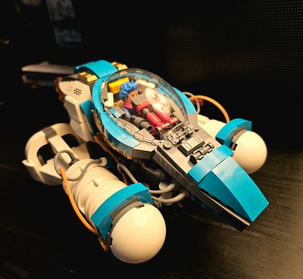 a lego space racer in white, teal, and dark grey