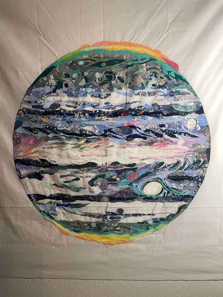 blue and green Jupiter (in infrared from JWST) made completely of small pieces of fabric. There are still some gaps where it’s not finished. 