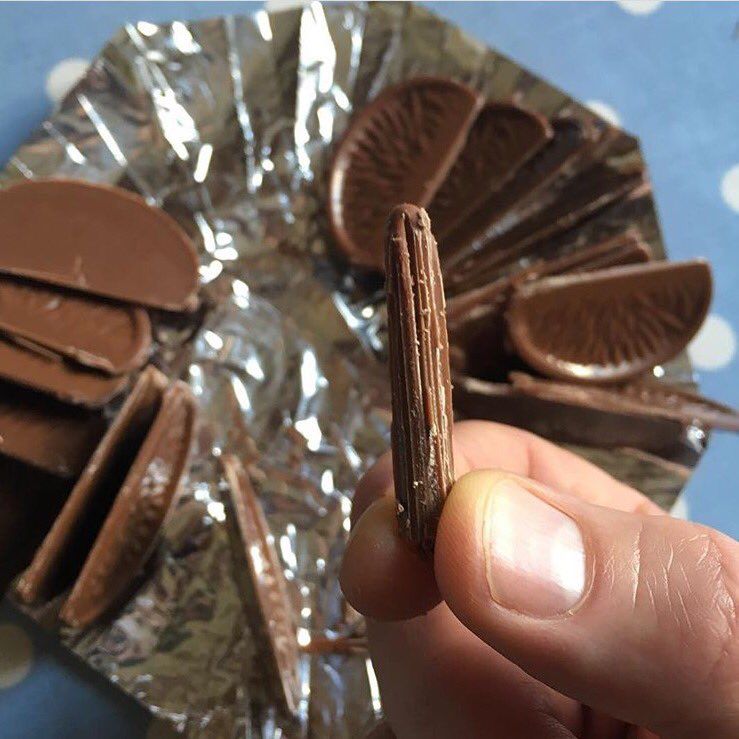 A tapped and unwrapped Terry’s Chocolate Orange - my hand is holding ‘the dowel’ - the most prized piece of this particular delicacy. 