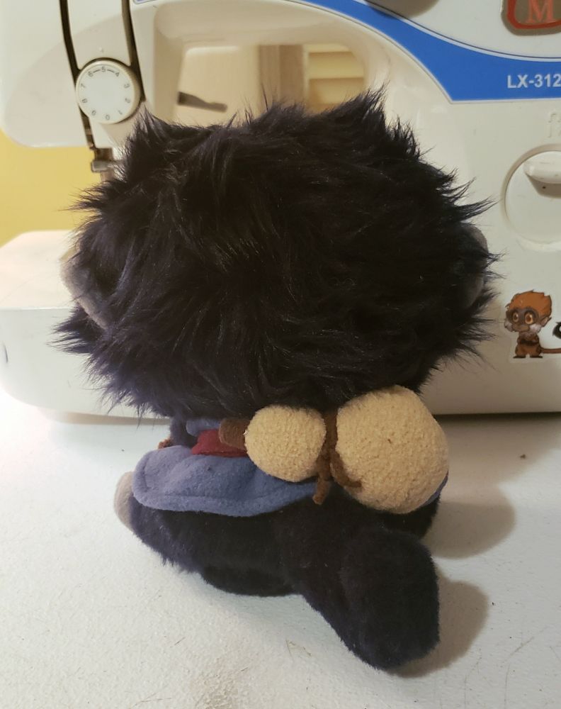 Rear view of shen monkey plush. Gourd is tied to red waistband for him to carry. 