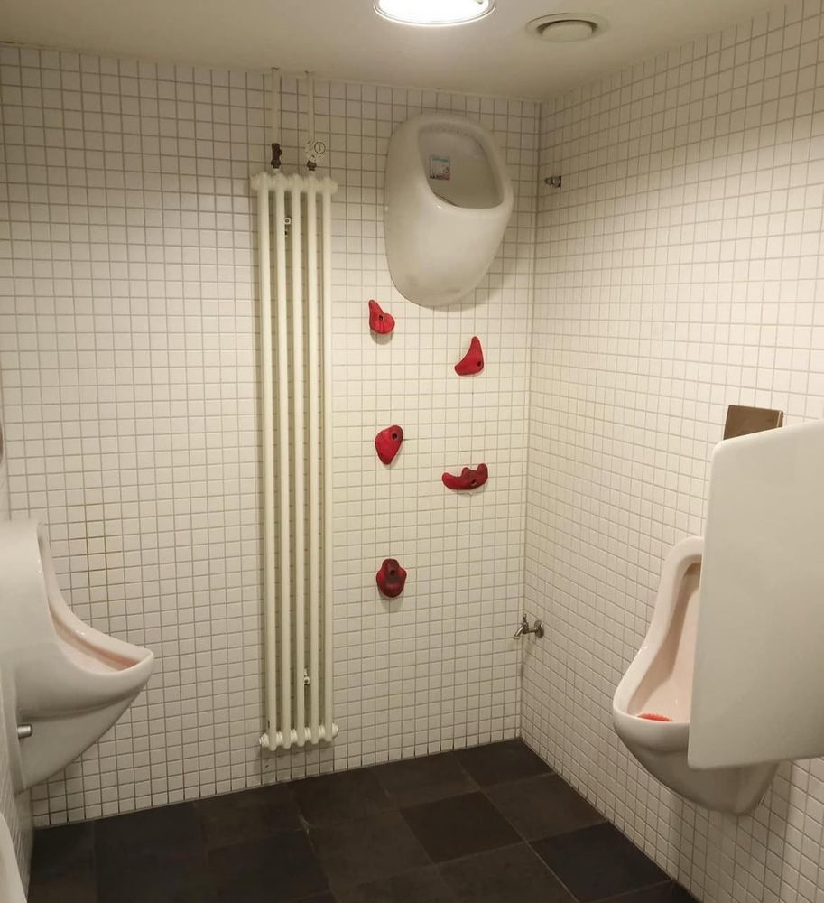 Ein pissoir oben an der Wald angebracht was nur zu erreichen ist wenn wie an einer Kletterwand hochklettert