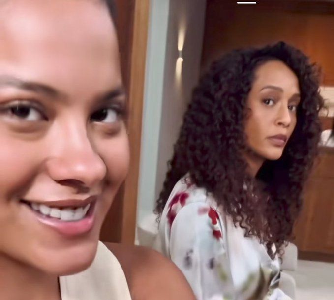 Atrizes Taís Araújo e Bella Campos como Maria de Fátima e Raquel Accioli em uma selfie.
Maria de Fátima está de camiseta branca e Raquel com uma camisa branca com detalhes vermelhos.