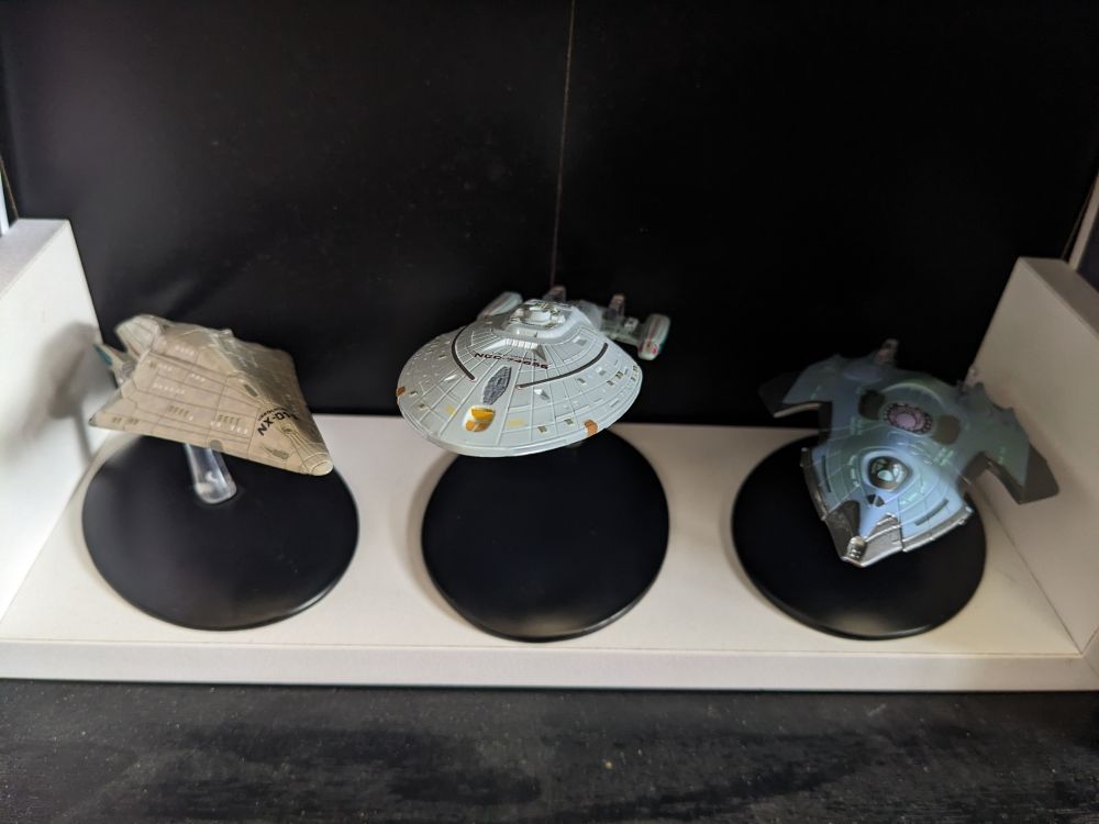 A collection of three Eaglemoss replica models, from left to right: 
- USS Dauntless,
- USS Voyager,
- USS Relativity 