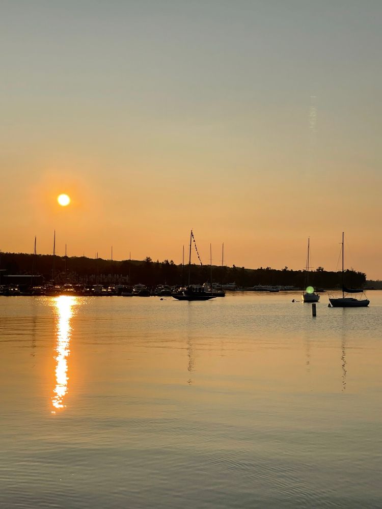Sunrise across the harbor in Harbor Springs on 8-1-25. No filters, simply smoke from the Manitoba wildfires. 