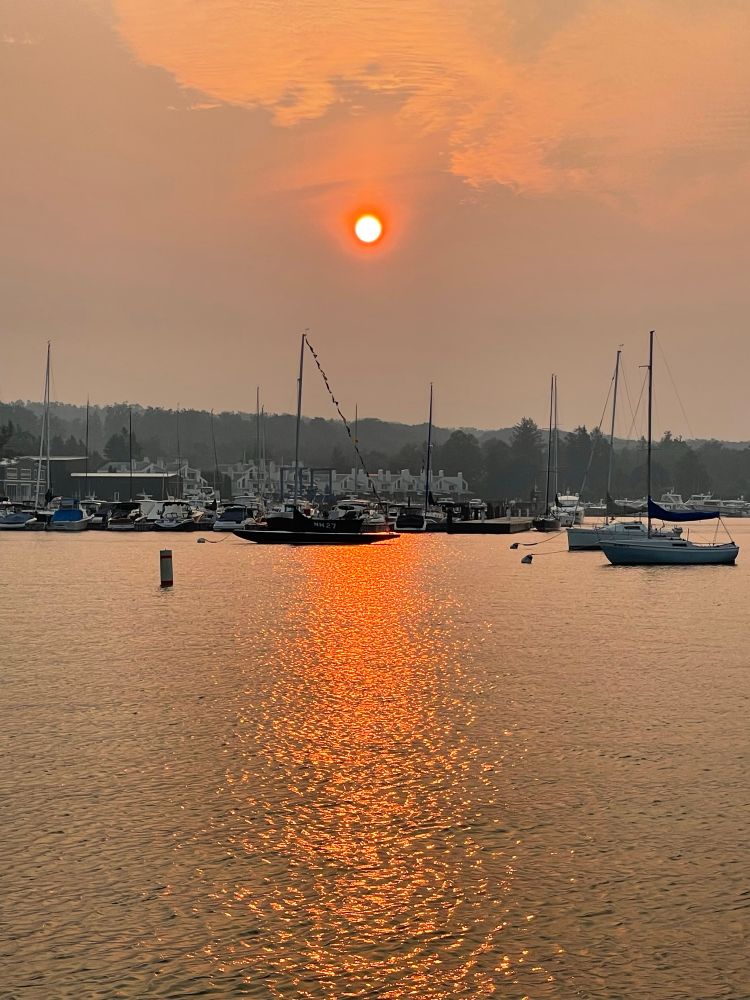 Sunrise from Harbor Springs MI on 7-31-25. No filters just the odd colors caused by smoke from wildfires in Manitoba. Extremely orange reflecting off the water. 