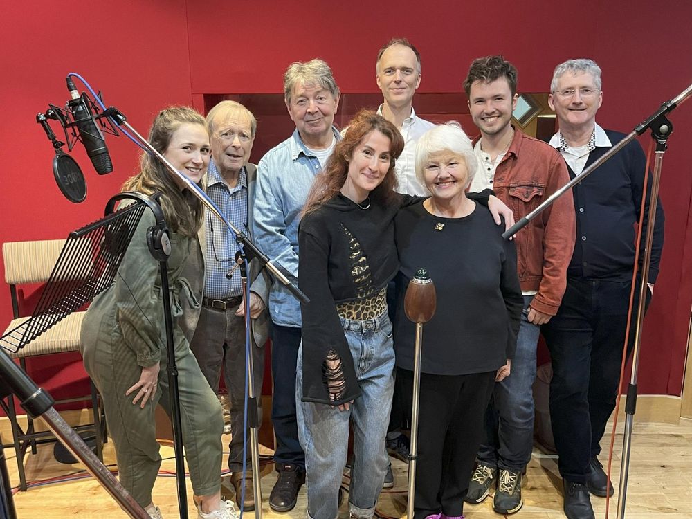 The cast and crew of Smith and Sullivan in the recording studio, surrounded by microphones. L-R; Rosie Baker, John Leeson, Graham Seed, Sadie Miller, Christopher Naylor, Annette Badland, Jonathan S Powell, Peter Angehlides. 