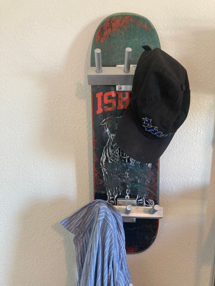 skateboard deck with custom-made hat/coat pegs instead of trucks