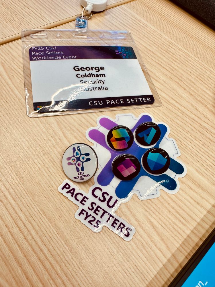 A picture of my event badge and sticker with little icon badges.