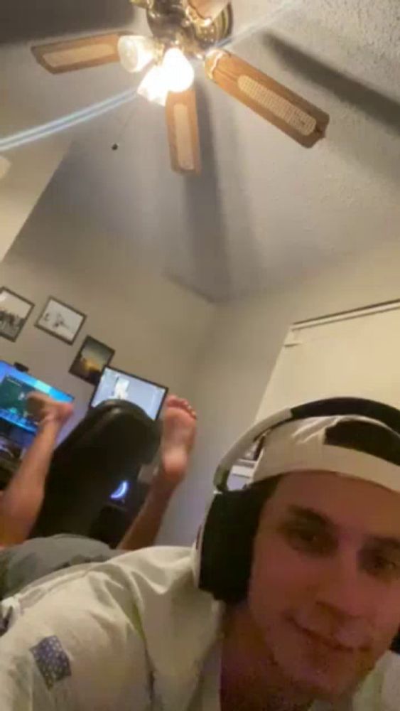 a man wearing headphones is taking a selfie with his feet up in the air