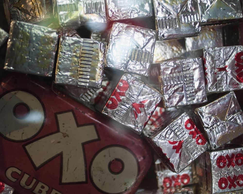 Foil wrapped stock cubes and an old tin with OXO written on them. 