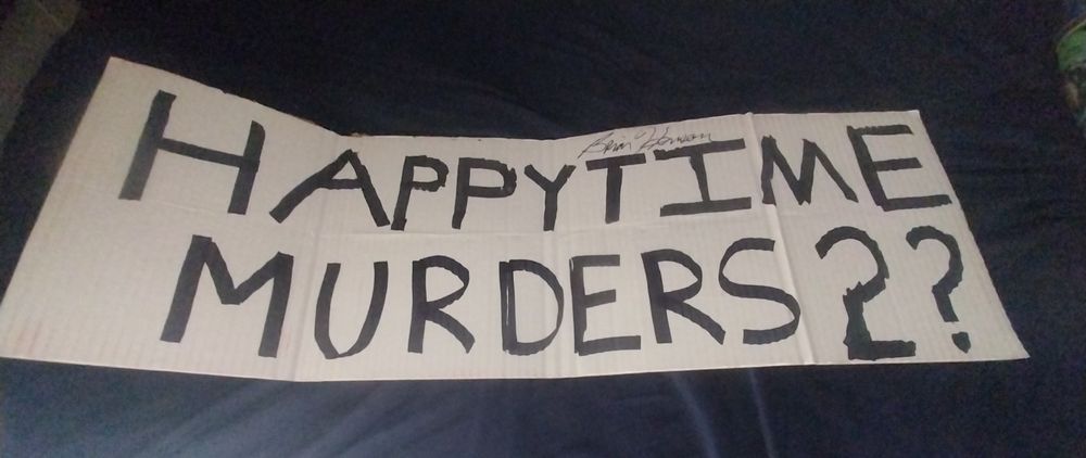 A cardboard sign signed by Brian Henson that says "Happytime Murders 2?"