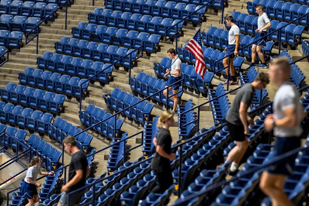 Cadets walk up and down stairs and one cadet carries an American flag
