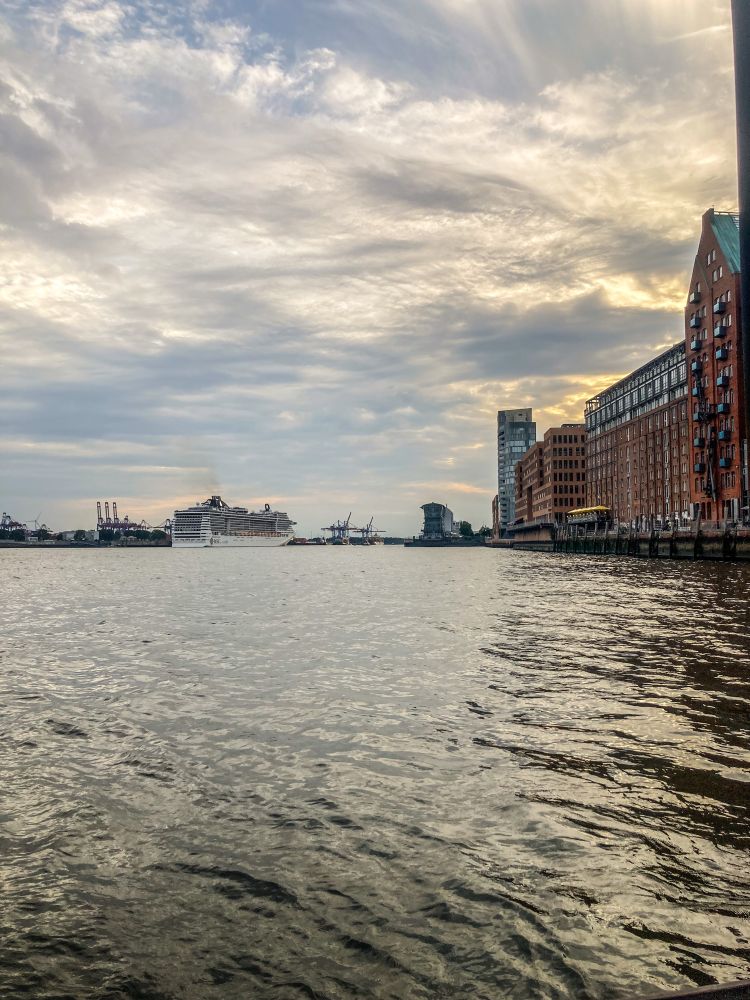 Blick auf den Hamburger Hafen und das Wasser der Elbe im Abendlicht. 
