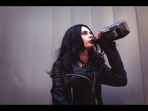 Jessica Jones drinking from a bottle of bourbon