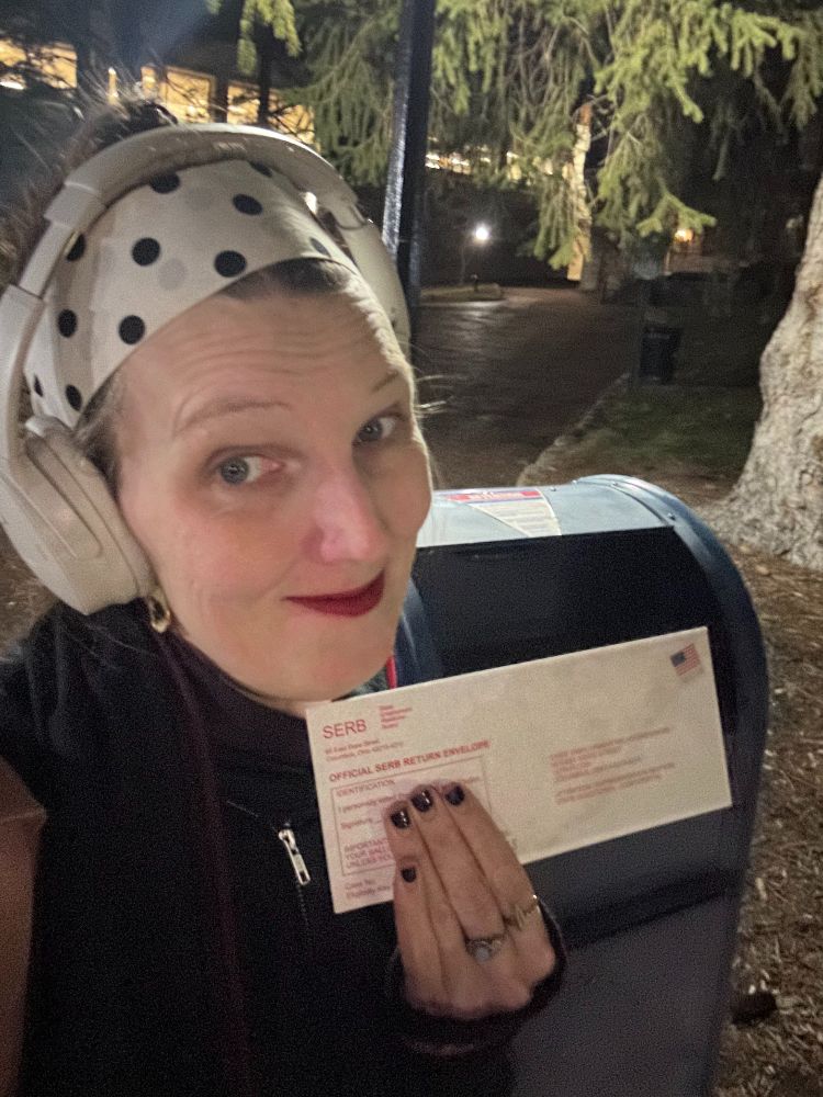Me standing in front of a mailbox with my union ballot envelope, smiling