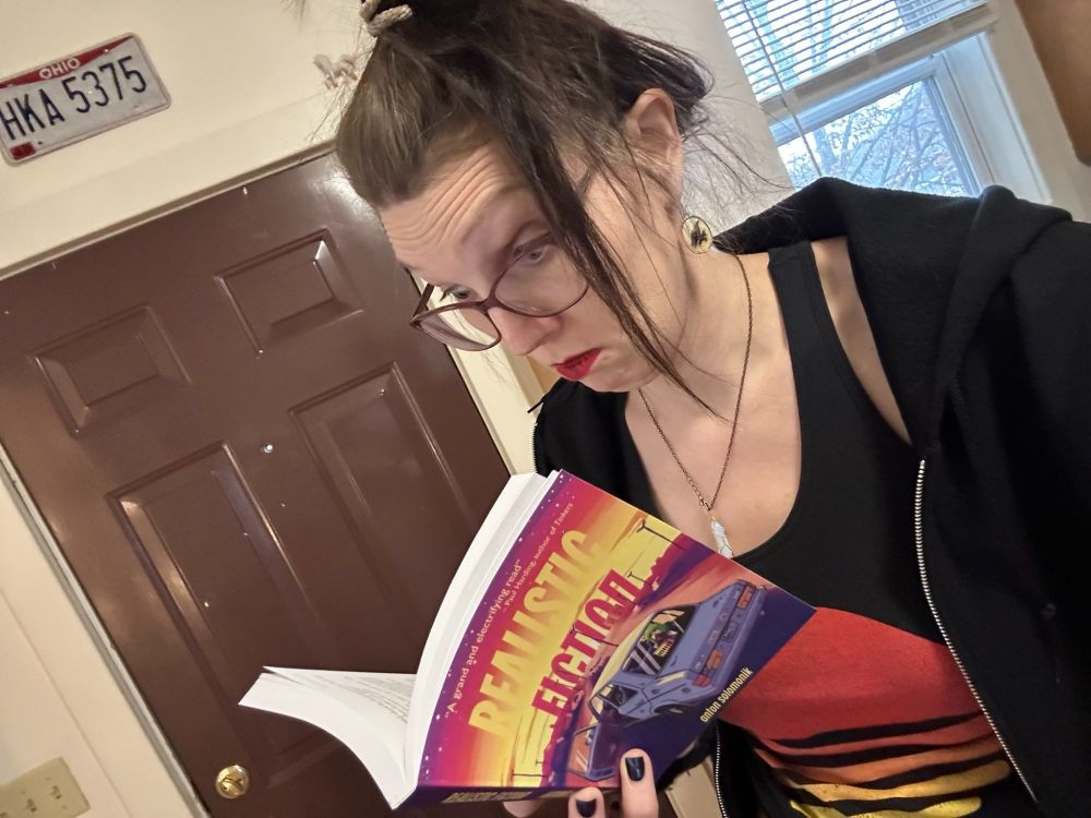 A photo of me reading Realistic Fiction, looking thoroughly engrossed and surprised