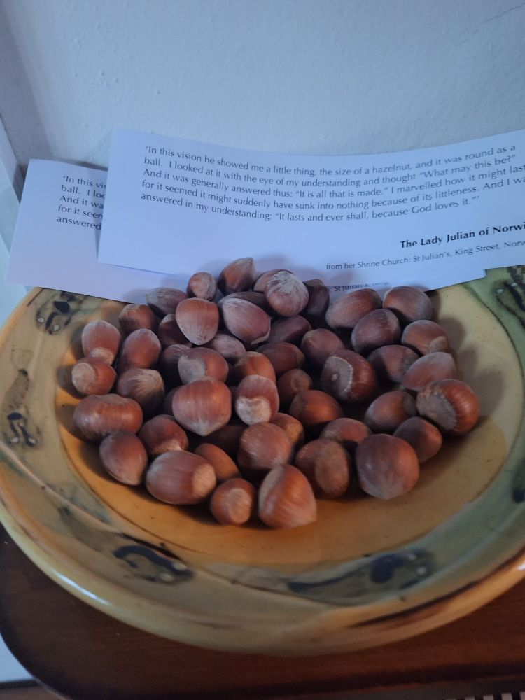 dish of hazlenuts and a little poster describing some of julian of norwich's meditations
