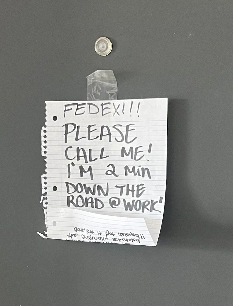 Sign taped on a door that says: "FedEx! Please call me! I'm 2 minutes down the road at work."